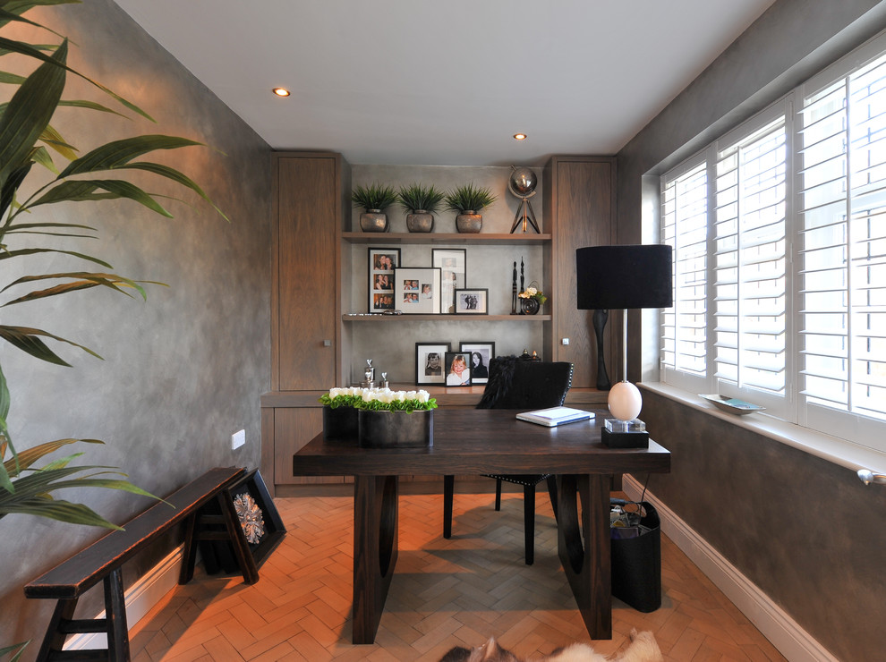 This is an example of a contemporary study in Surrey with grey walls and a freestanding desk.