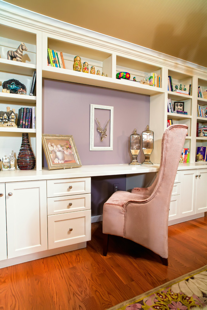 Example of a mid-sized trendy built-in desk dark wood floor and brown floor study room design in St Louis with purple walls