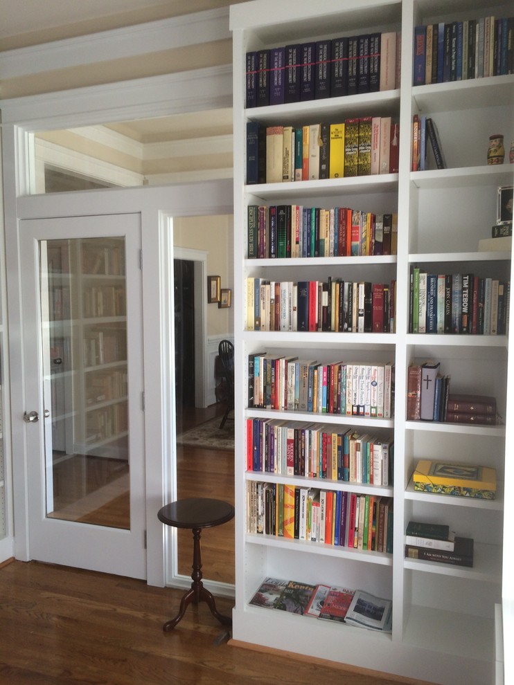 Aménagement d'un petit bureau classique avec une bibliothèque ou un coin lecture, un mur beige, un sol en bois brun, aucune cheminée et un sol marron.