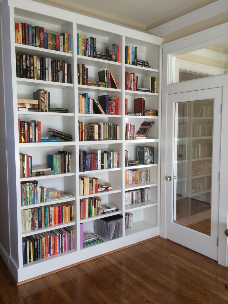 Inspiration för små klassiska arbetsrum, med ett bibliotek, beige väggar, mellanmörkt trägolv och brunt golv