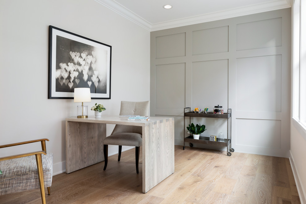 Imagen de despacho clásico renovado de tamaño medio con paredes grises, suelo de madera clara, escritorio independiente, suelo beige y panelado