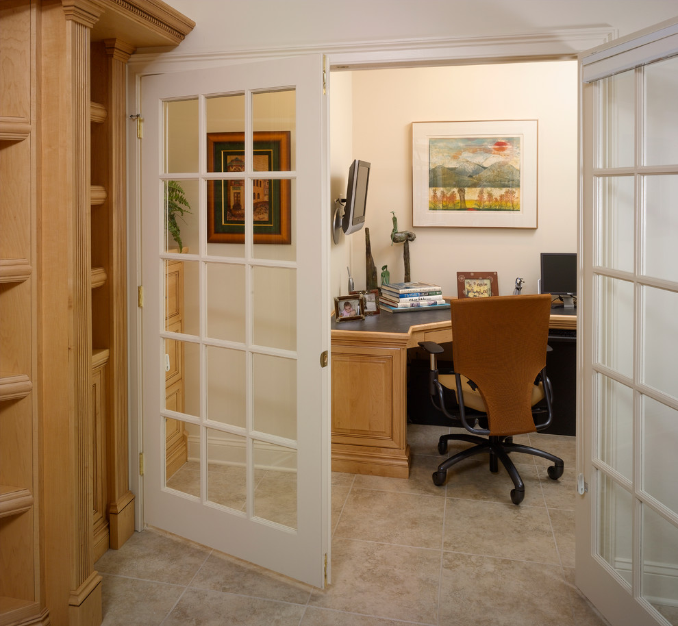 Cette image montre un petit bureau sud-ouest américain avec un mur beige, un sol en carrelage de porcelaine, aucune cheminée et un bureau intégré.