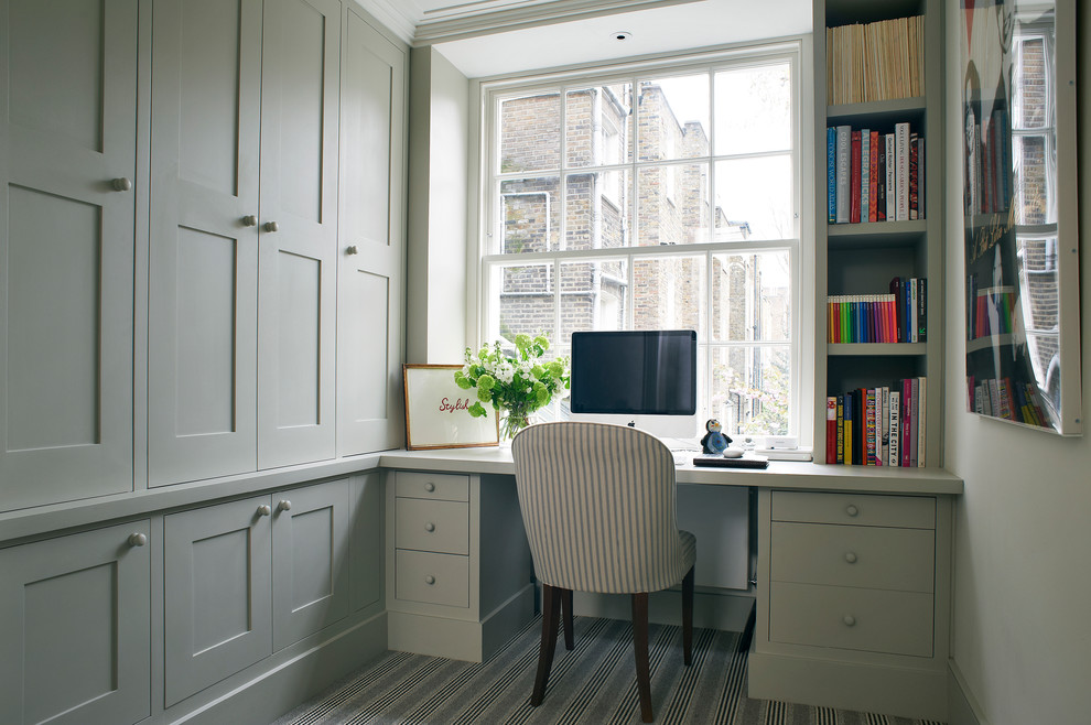 Foto på ett arbetsrum, med grå väggar, heltäckningsmatta och ett inbyggt skrivbord