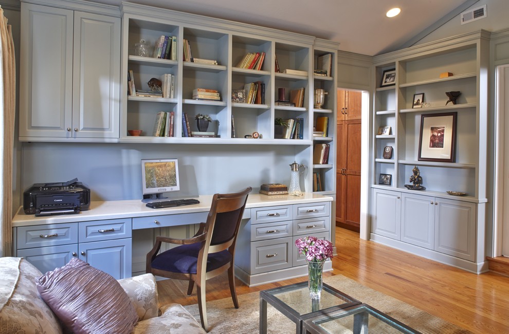 Ejemplo de despacho tradicional de tamaño medio con paredes azules, suelo de madera en tonos medios y escritorio empotrado