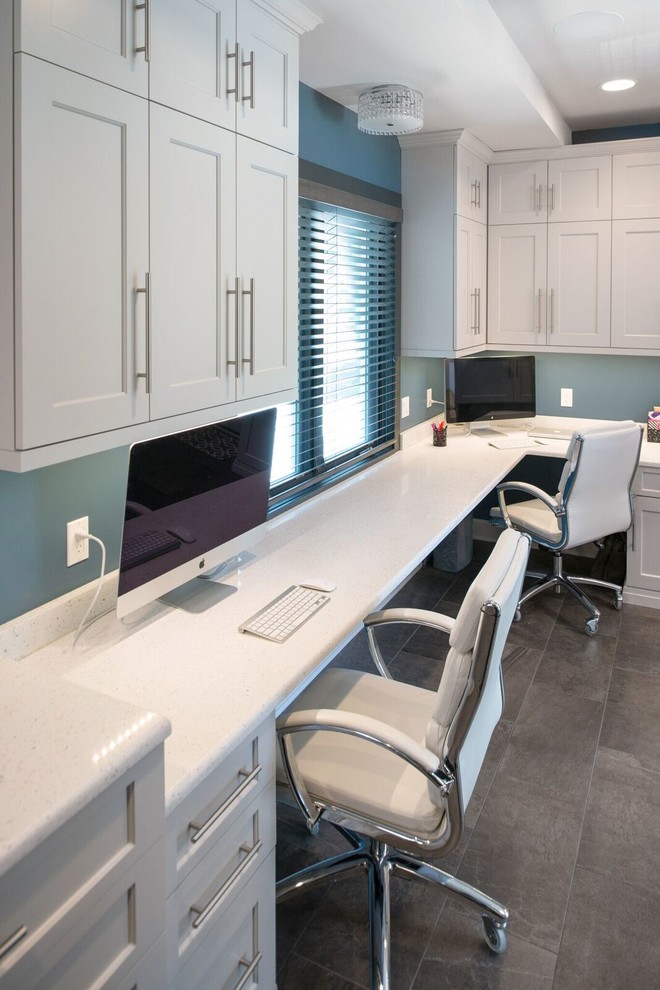 Imagen de despacho tradicional grande sin chimenea con paredes azules, escritorio empotrado, suelo de cemento y suelo gris