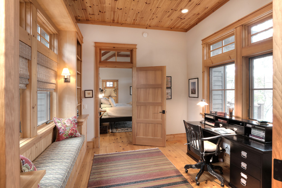 Cette image montre un petit bureau traditionnel avec un sol en bois brun, un bureau indépendant et un mur blanc.