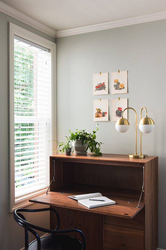 Modelo de despacho tradicional renovado pequeño con paredes azules, suelo de madera en tonos medios, escritorio independiente y suelo marrón