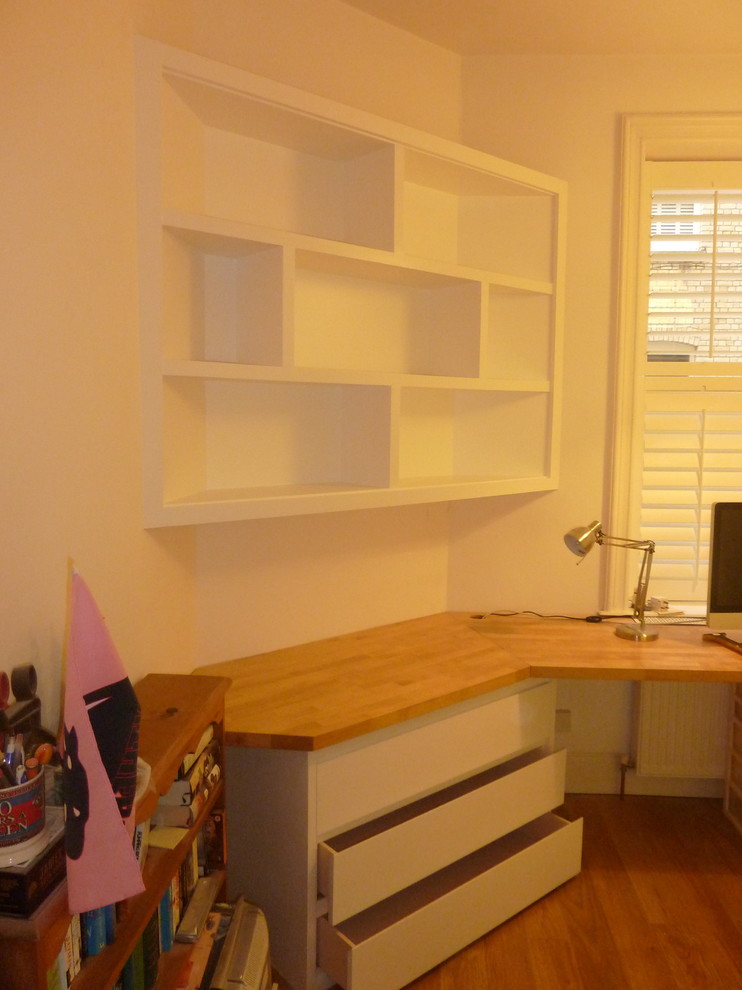 Idée de décoration pour un bureau design de taille moyenne avec un mur blanc, un sol en bois brun et un bureau intégré.