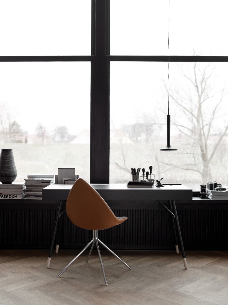 Cette image montre un bureau nordique de taille moyenne avec un mur noir, parquet clair, aucune cheminée, un bureau indépendant et un sol marron.