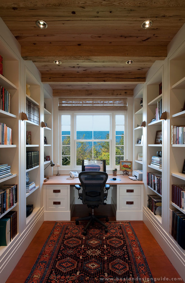 This is an example of a medium sized rural study in Boston with a built-in desk, white walls and medium hardwood flooring.