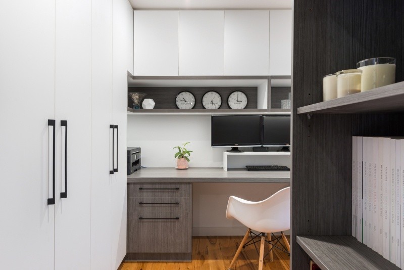 Großes Modernes Arbeitszimmer mit Arbeitsplatz, weißer Wandfarbe, braunem Holzboden und Einbau-Schreibtisch in Melbourne