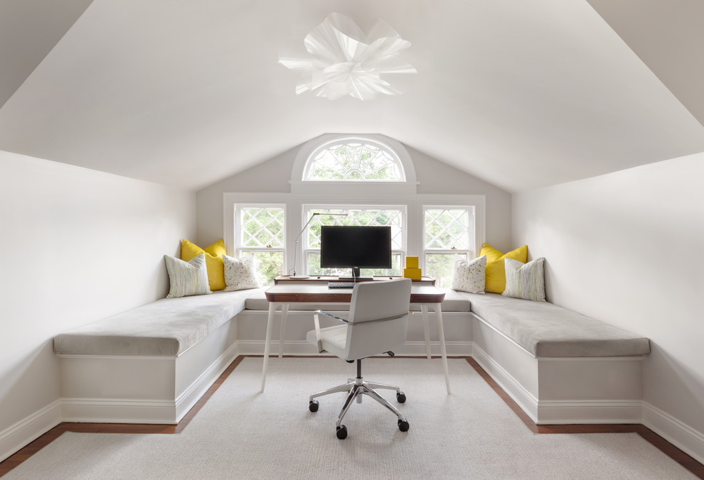 Idéer för ett klassiskt arbetsrum, med vita väggar, mellanmörkt trägolv, ett fristående skrivbord och brunt golv
