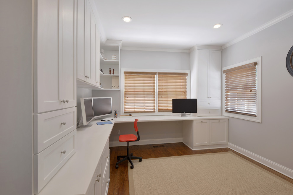 Imagen de despacho contemporáneo grande con paredes blancas, suelo de madera en tonos medios y escritorio empotrado