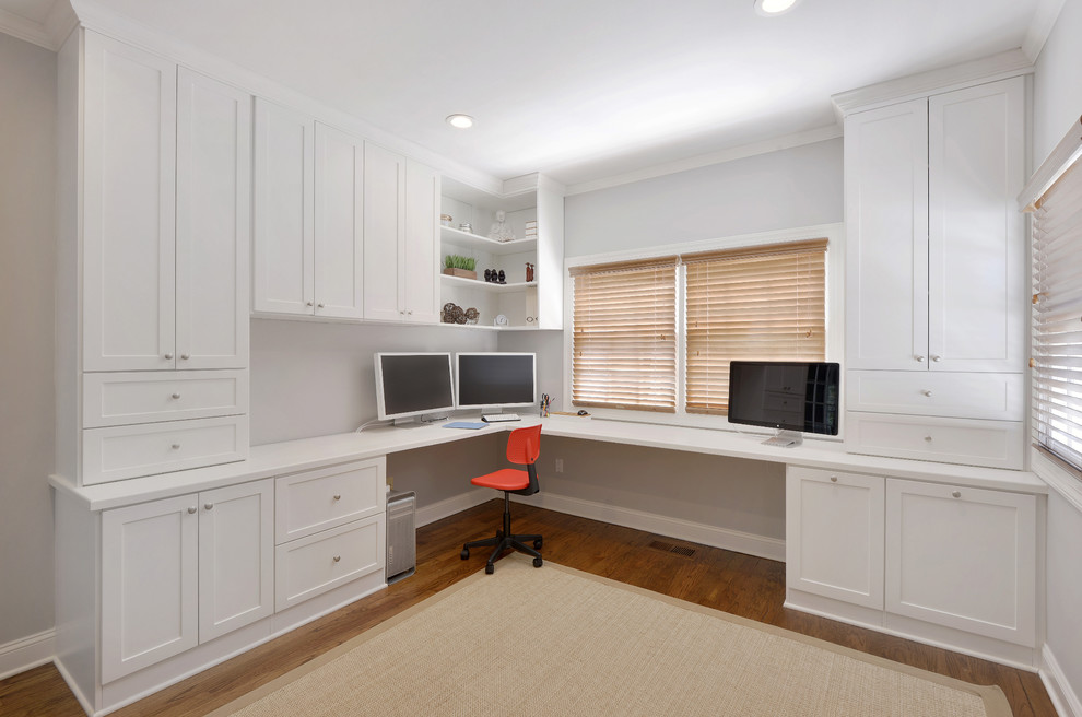 Diseño de despacho contemporáneo grande con paredes blancas, suelo de madera en tonos medios y escritorio empotrado