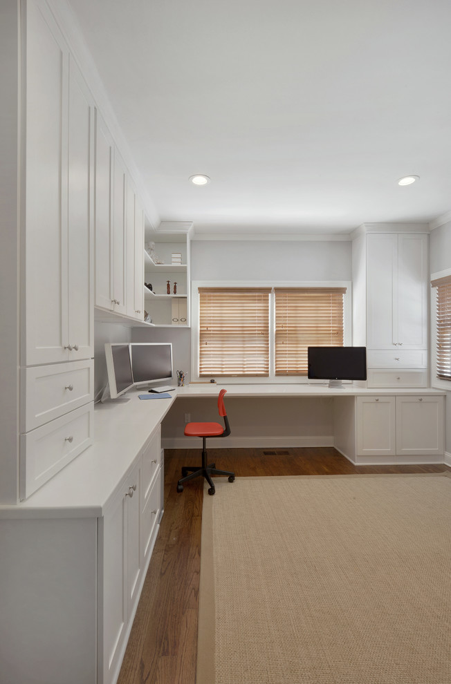 Ispirazione per un grande studio minimal con pareti bianche, pavimento in legno massello medio e scrivania incassata