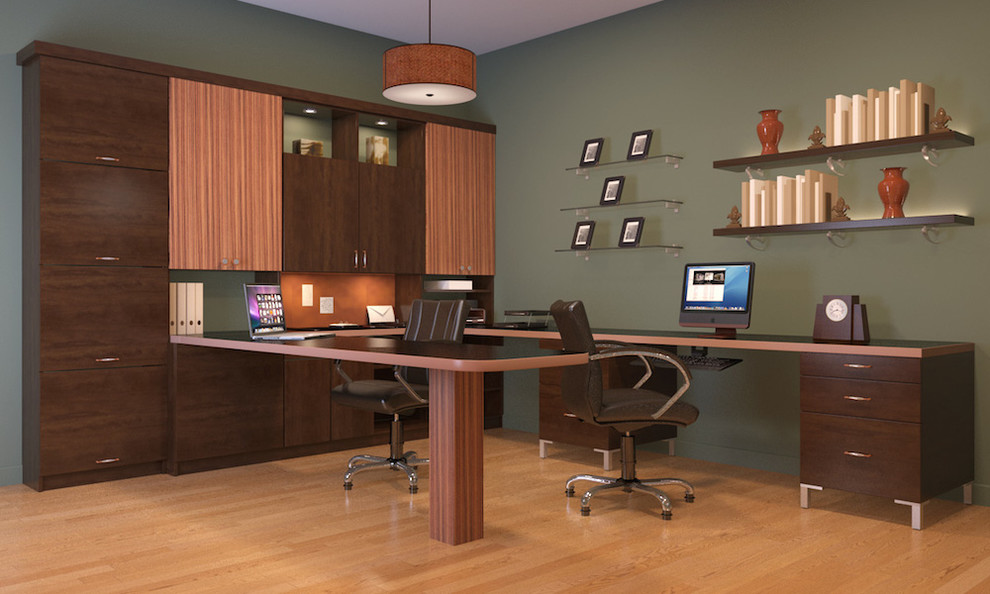 Modelo de despacho moderno de tamaño medio con paredes verdes, suelo de madera clara y escritorio empotrado