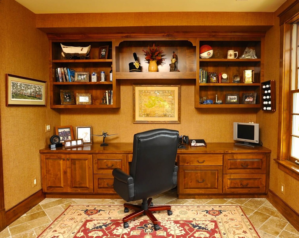 Foto på ett mellanstort lantligt hemmabibliotek, med beige väggar, travertin golv, ett inbyggt skrivbord och beiget golv