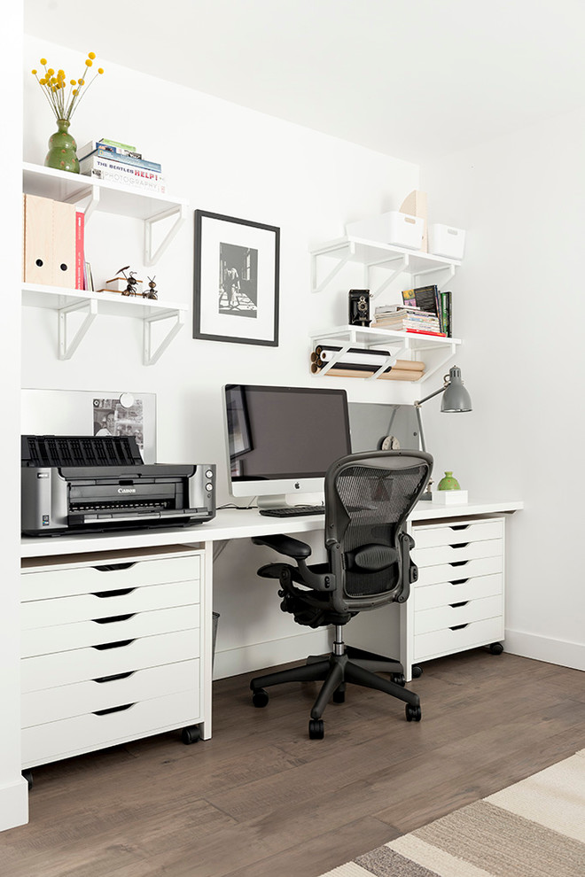 Modelo de despacho clásico renovado de tamaño medio con paredes blancas, suelo de madera en tonos medios y escritorio empotrado
