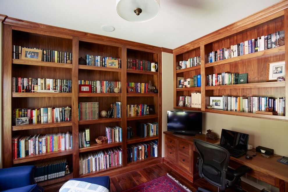 Medium sized country study in Minneapolis with beige walls, medium hardwood flooring, a built-in desk and brown floors.