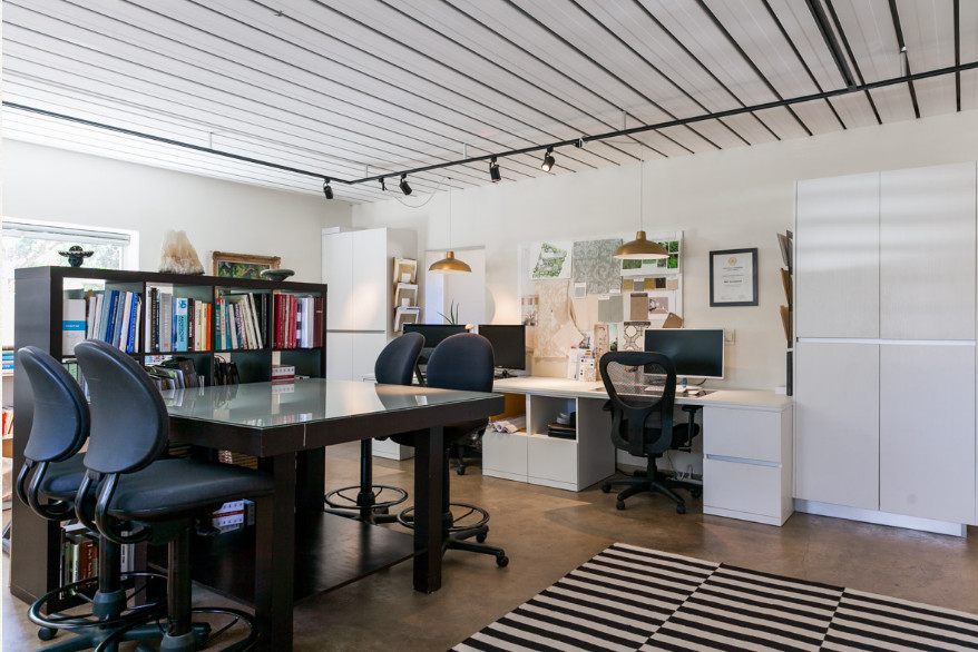 Immagine di una stanza da lavoro minimal di medie dimensioni con pareti bianche, pavimento in cemento, scrivania incassata e pavimento grigio
