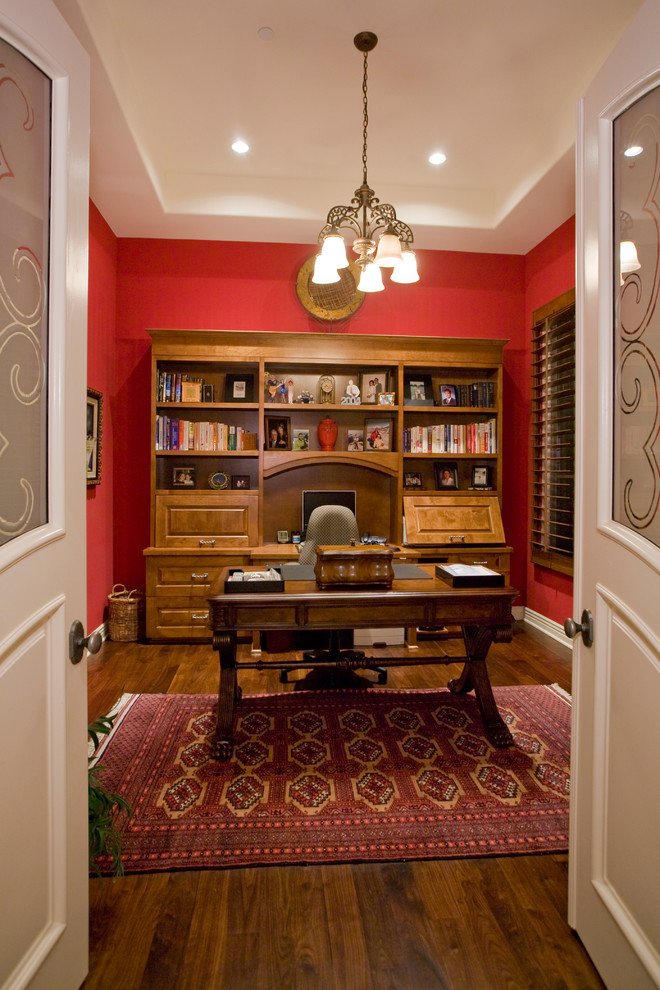 Home office - mid-sized traditional freestanding desk dark wood floor home office idea in Phoenix with red walls and no fireplace