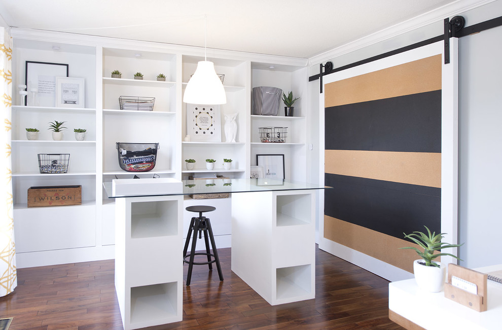 Inspiration för moderna arbetsrum, med grå väggar, mörkt trägolv och ett fristående skrivbord