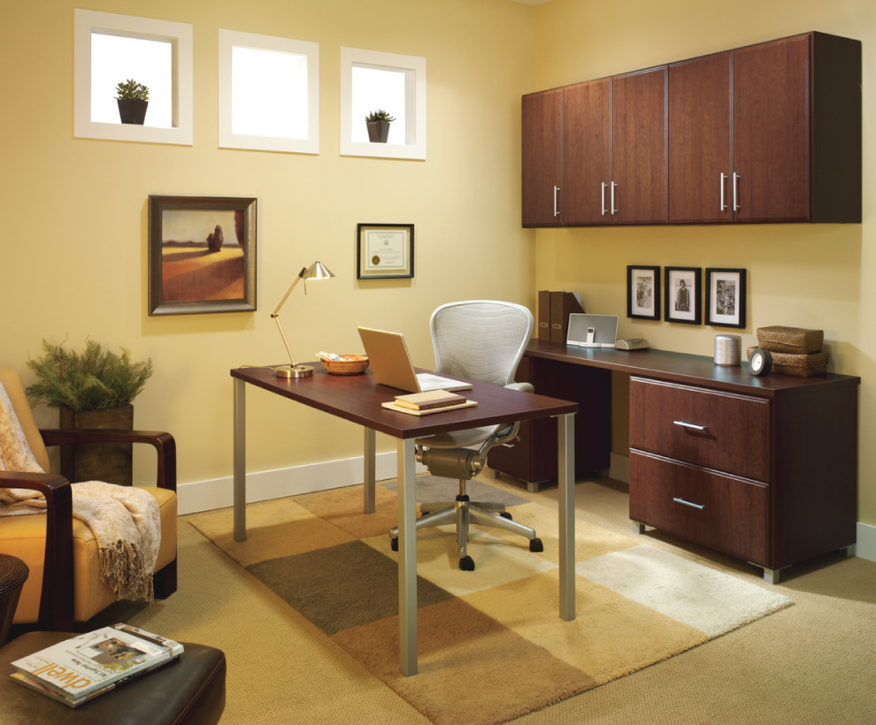 Пример оригинального дизайна: рабочее место среднего размера в классическом стиле с желтыми стенами, ковровым покрытием и отдельно стоящим рабочим столом без камина