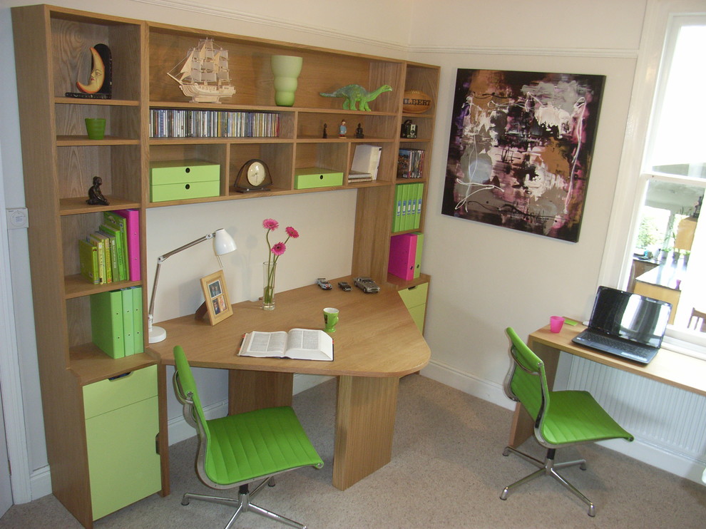 This is an example of a medium sized contemporary study in Other with beige walls, carpet and a built-in desk.