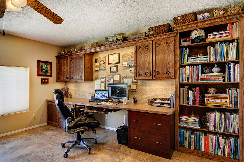 This is an example of a medium sized traditional home office in Albuquerque with beige walls, porcelain flooring, no fireplace and a built-in desk.