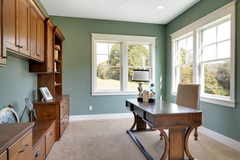 Immagine di un ufficio country con pareti verdi, moquette e scrivania autoportante