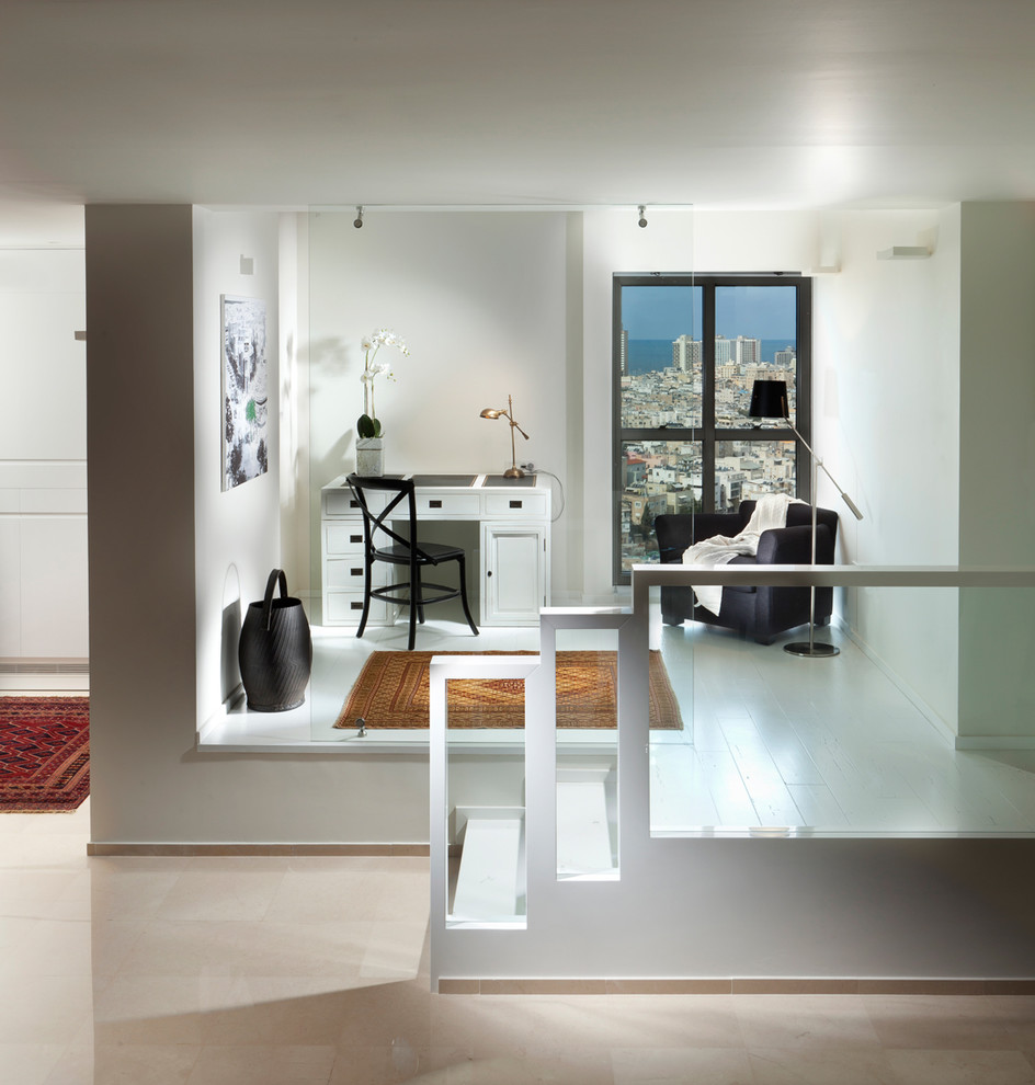 Immagine di uno studio design con pareti bianche, pavimento in legno verniciato e scrivania autoportante