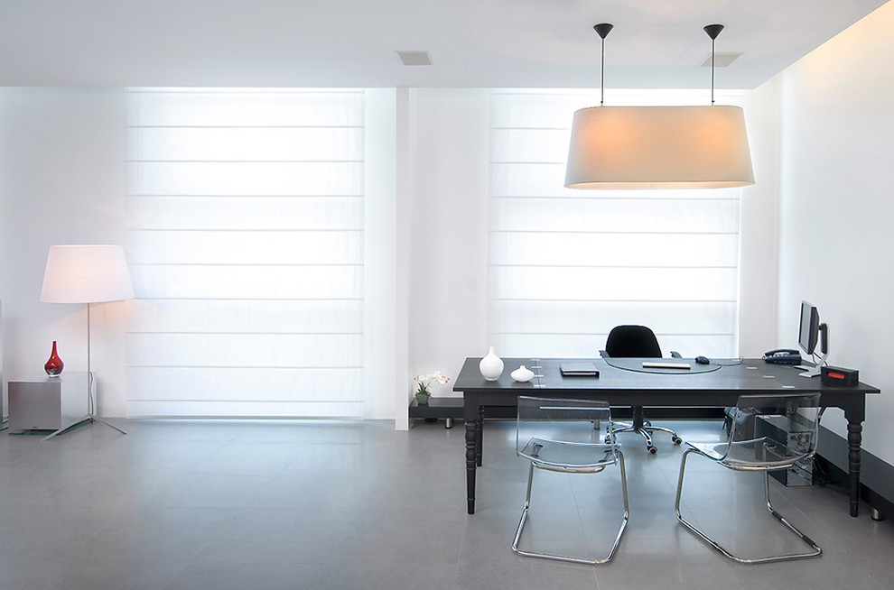 На фото: большой кабинет в стиле модернизм с белыми стенами и отдельно стоящим рабочим столом
