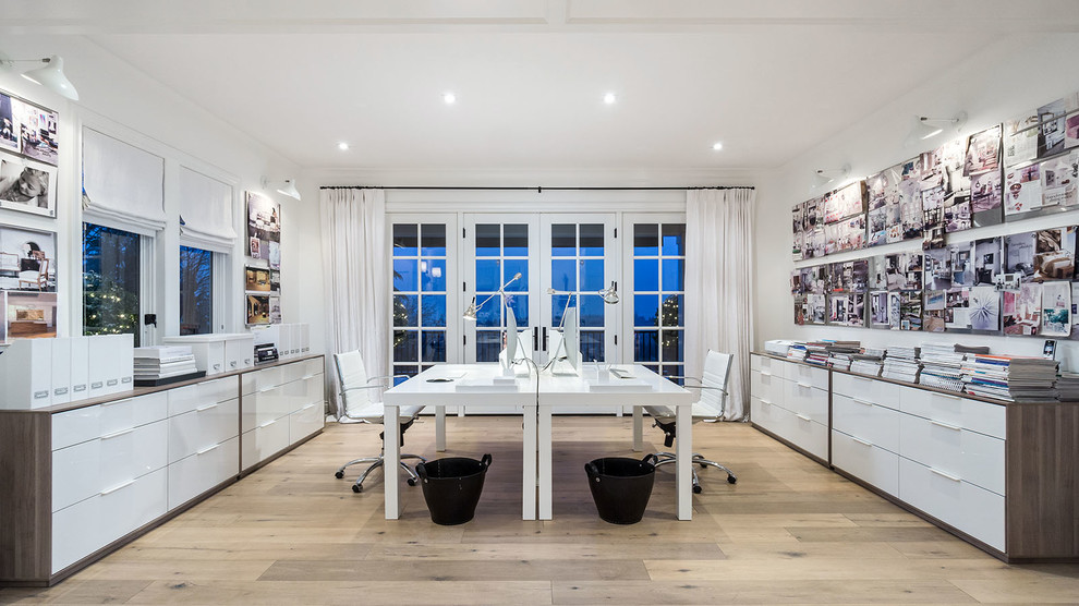 Example of a trendy freestanding desk light wood floor home studio design in Portland with white walls