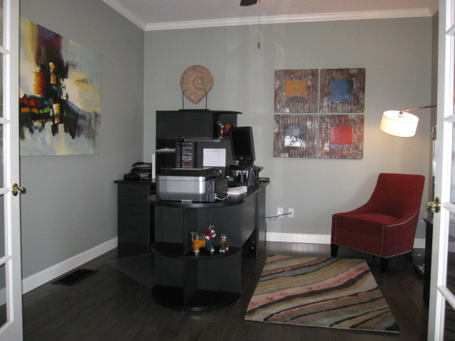 Esempio di un piccolo ufficio design con pareti grigie, pavimento in laminato e scrivania autoportante