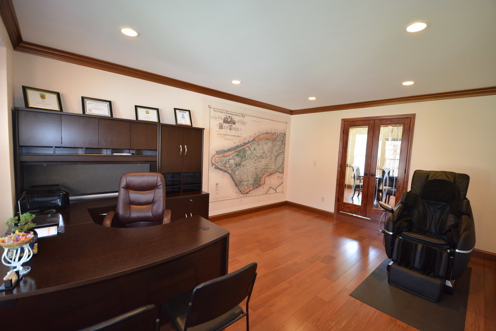 Large elegant built-in desk medium tone wood floor and brown floor study room photo in Baltimore with white walls and no fireplace