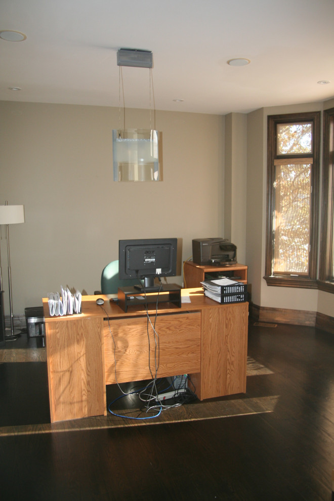 Modelo de despacho actual de tamaño medio con paredes beige y suelo de madera en tonos medios