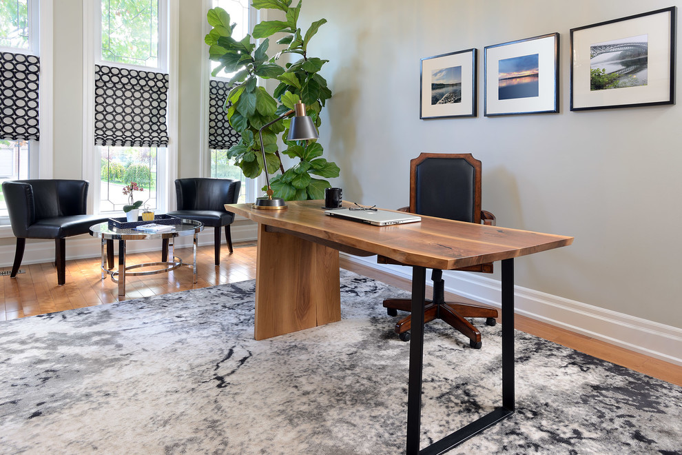 Foto di un atelier tradizionale di medie dimensioni con pareti grigie, pavimento in legno massello medio, scrivania autoportante e pavimento marrone
