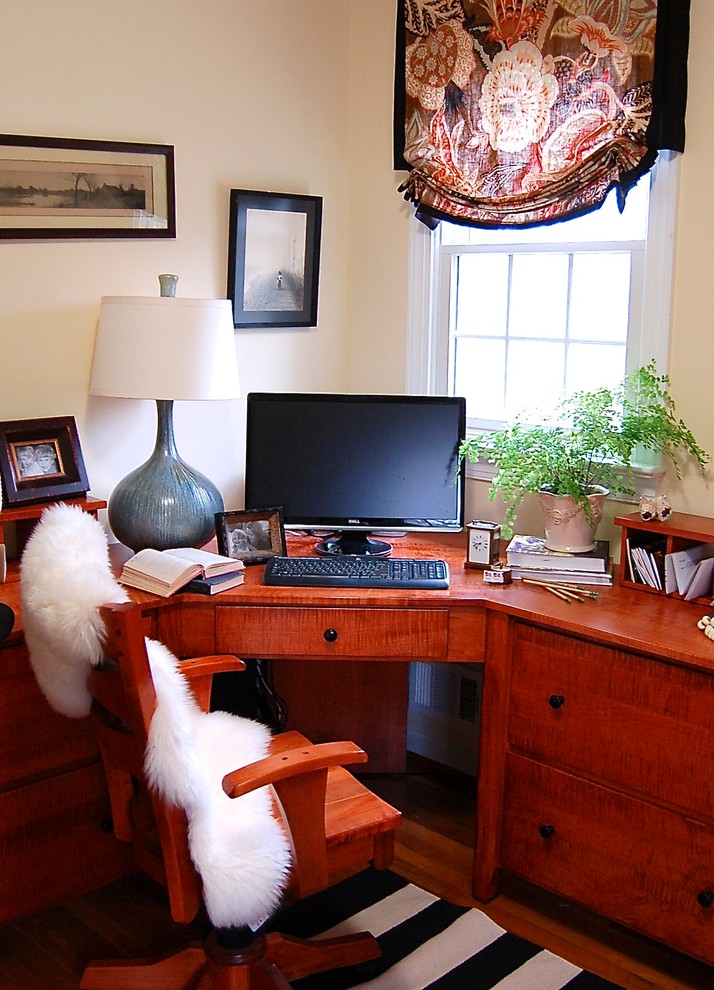 Imagen de despacho de tamaño medio sin chimenea con paredes amarillas, suelo de madera en tonos medios y escritorio independiente