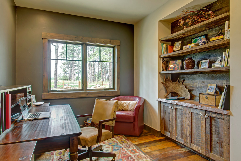 Imagen de despacho rústico con paredes grises, suelo de madera en tonos medios y escritorio independiente