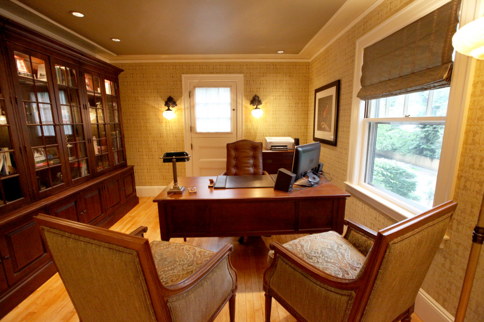 Mittelgroßes Klassisches Lesezimmer mit beiger Wandfarbe, braunem Holzboden, freistehendem Schreibtisch und braunem Boden in Boston