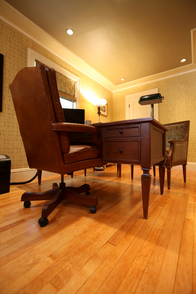 Inspiration för ett mellanstort vintage arbetsrum, med ett bibliotek, beige väggar, mellanmörkt trägolv, ett fristående skrivbord och brunt golv