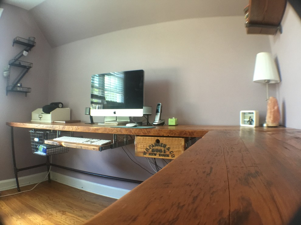 Bild på ett mellanstort industriellt arbetsrum, med beige väggar, mellanmörkt trägolv och ett fristående skrivbord