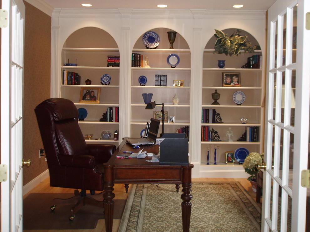 Cette photo montre un bureau chic de taille moyenne avec une bibliothèque ou un coin lecture, un mur marron, parquet clair, aucune cheminée et un bureau indépendant.