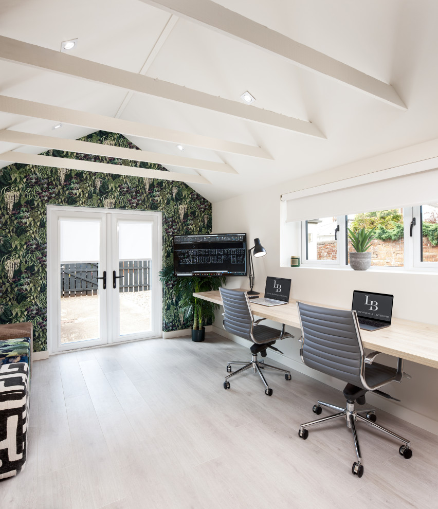 Immagine di un grande ufficio minimal con pareti beige, parquet chiaro, scrivania incassata e pavimento beige