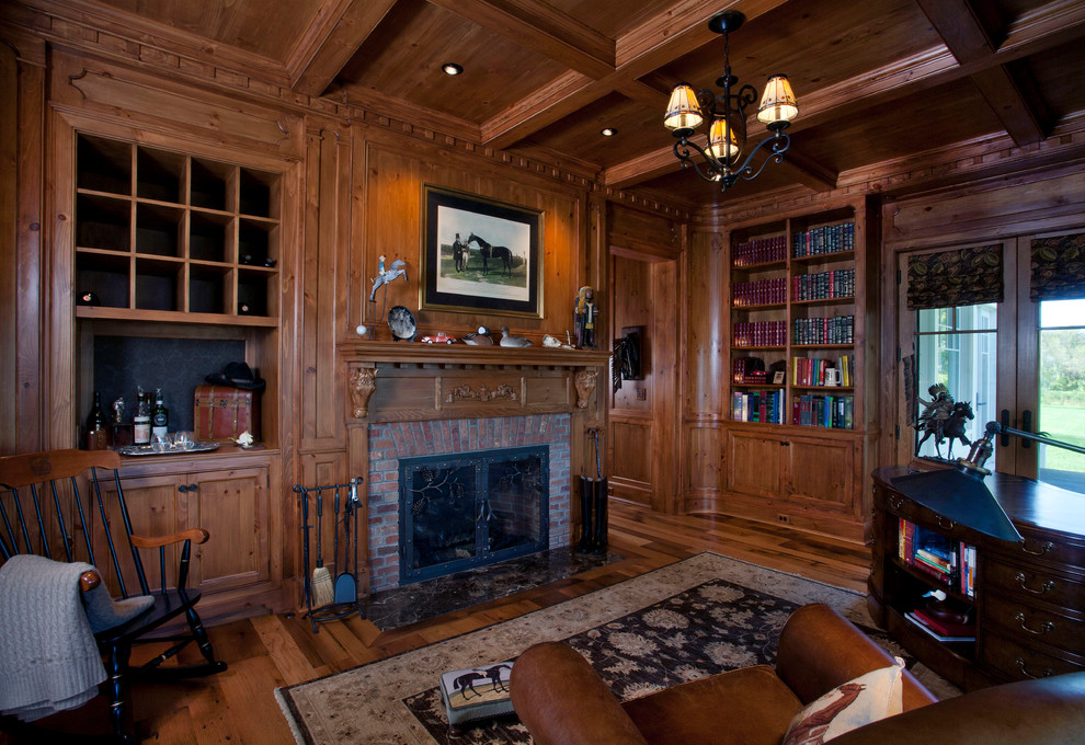 Großes Country Lesezimmer mit brauner Wandfarbe, braunem Holzboden, Kamin, Kaminumrandung aus Backstein und freistehendem Schreibtisch in New York