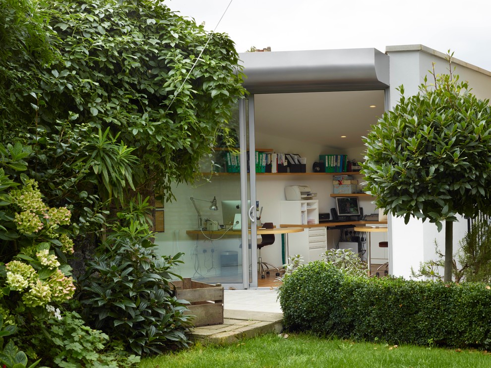 Kleines Modernes Arbeitszimmer mit weißer Wandfarbe, hellem Holzboden und Einbau-Schreibtisch in London