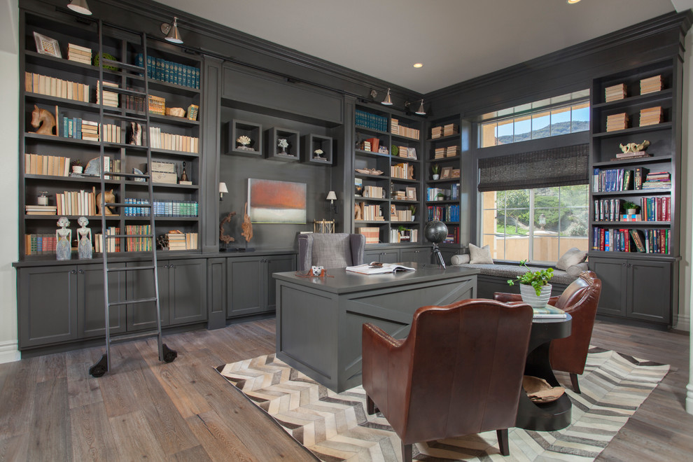 Large elegant freestanding desk dark wood floor home office photo in Orange County with gray walls