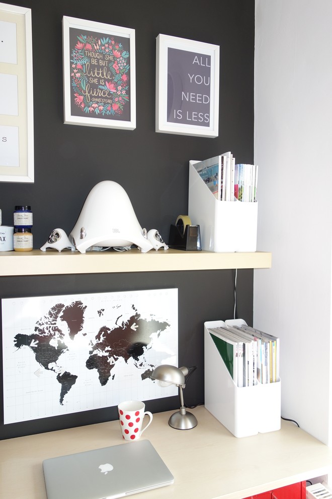 This is an example of a small contemporary study in Other with black walls, carpet and a freestanding desk.