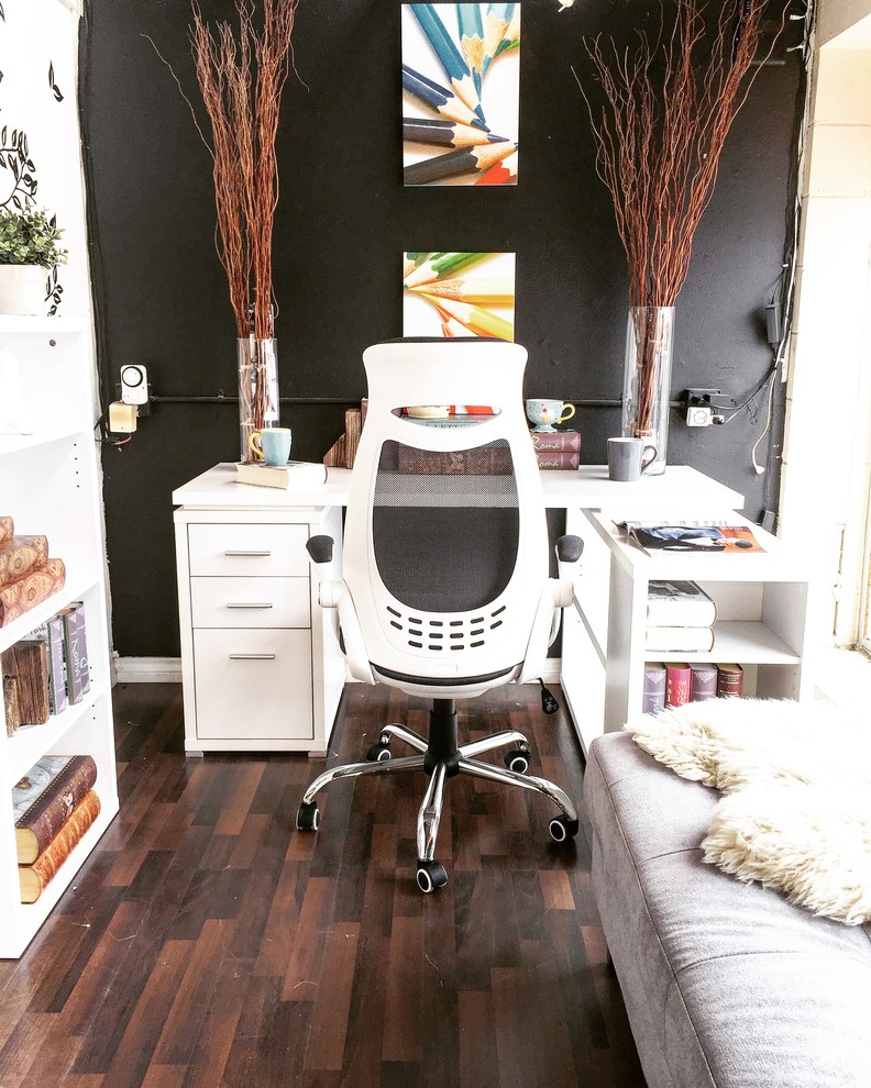 Kleines Shabby-Look Arbeitszimmer mit Arbeitsplatz, schwarzer Wandfarbe, Laminat, freistehendem Schreibtisch und braunem Boden in Vancouver