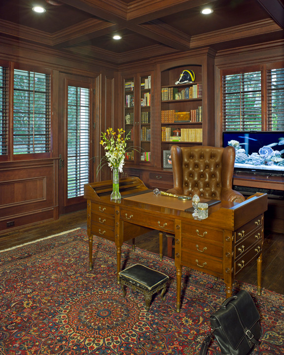 Classic study in Detroit with brown walls, medium hardwood flooring and a freestanding desk.
